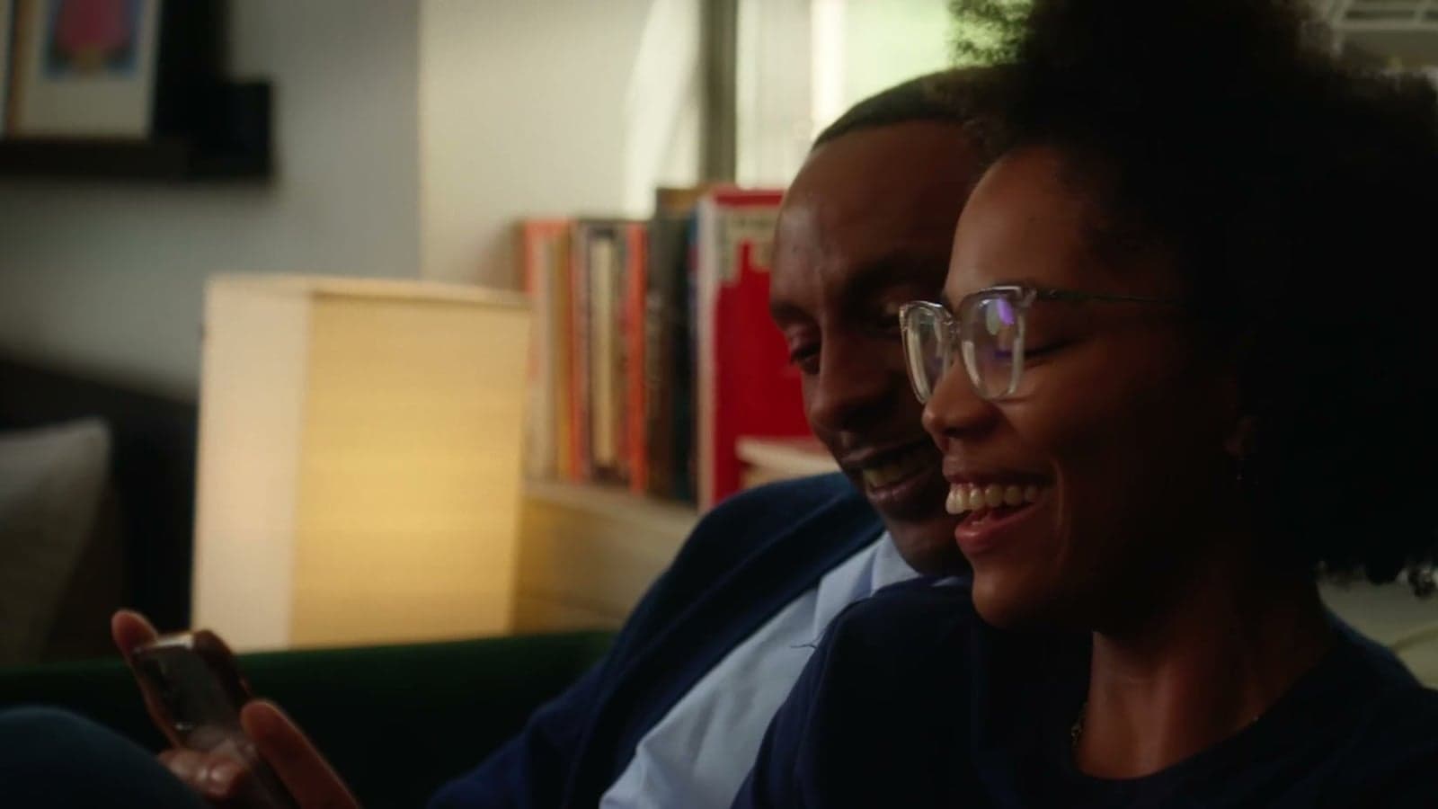 A couple laughing together on the couch at home